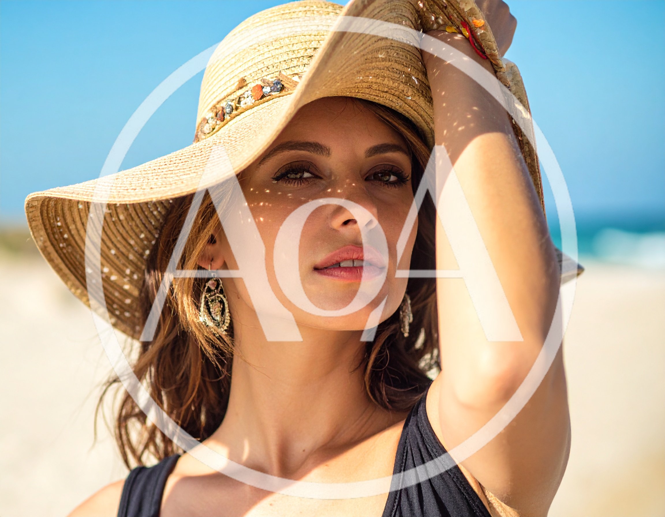 Beautiful Woman Wearing A Straw Hat On The Beach