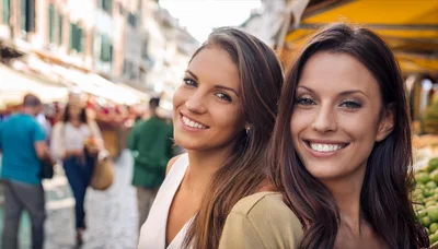 Two Beautiful Women Smiling Together At An Outdoor Market