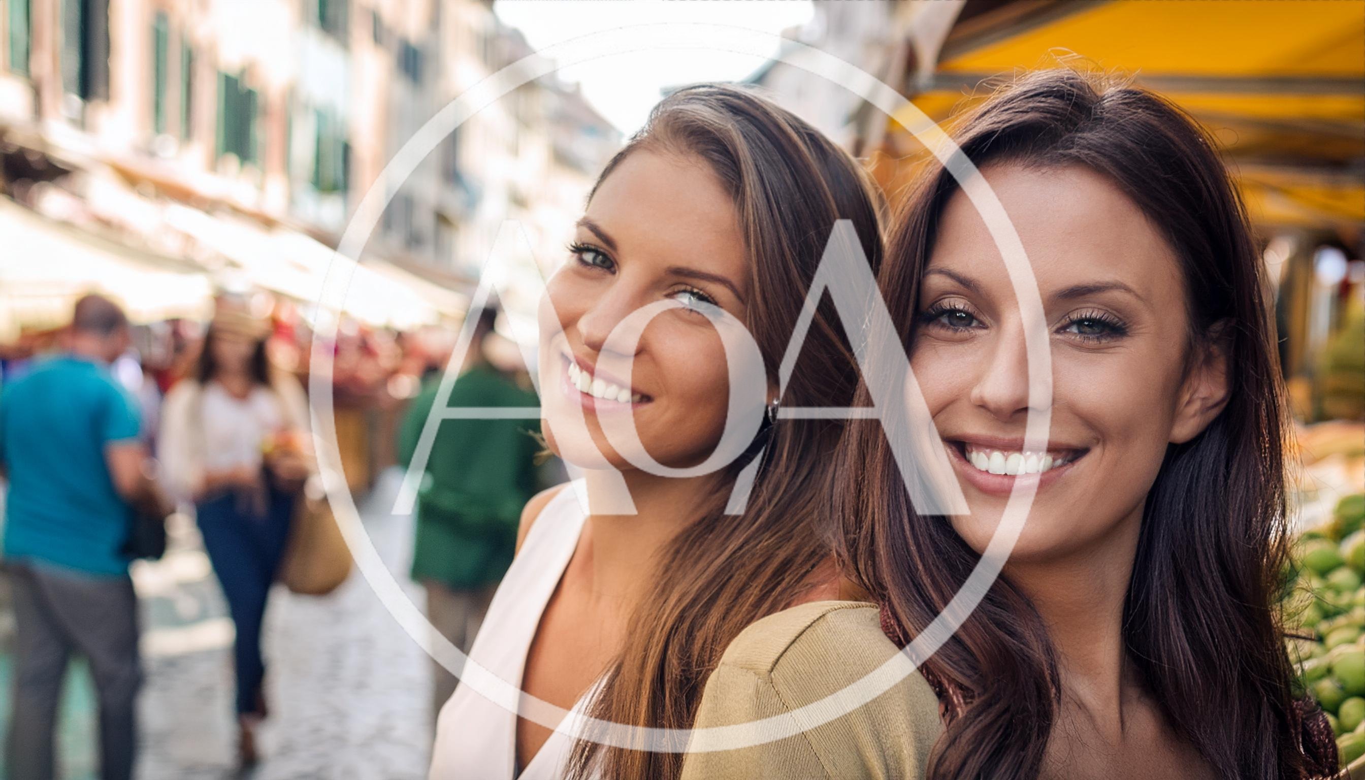 Two Beautiful Women Smiling Together At An Outdoor Market
