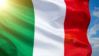 Italian Flag Waving Against A Bright Blue Sky