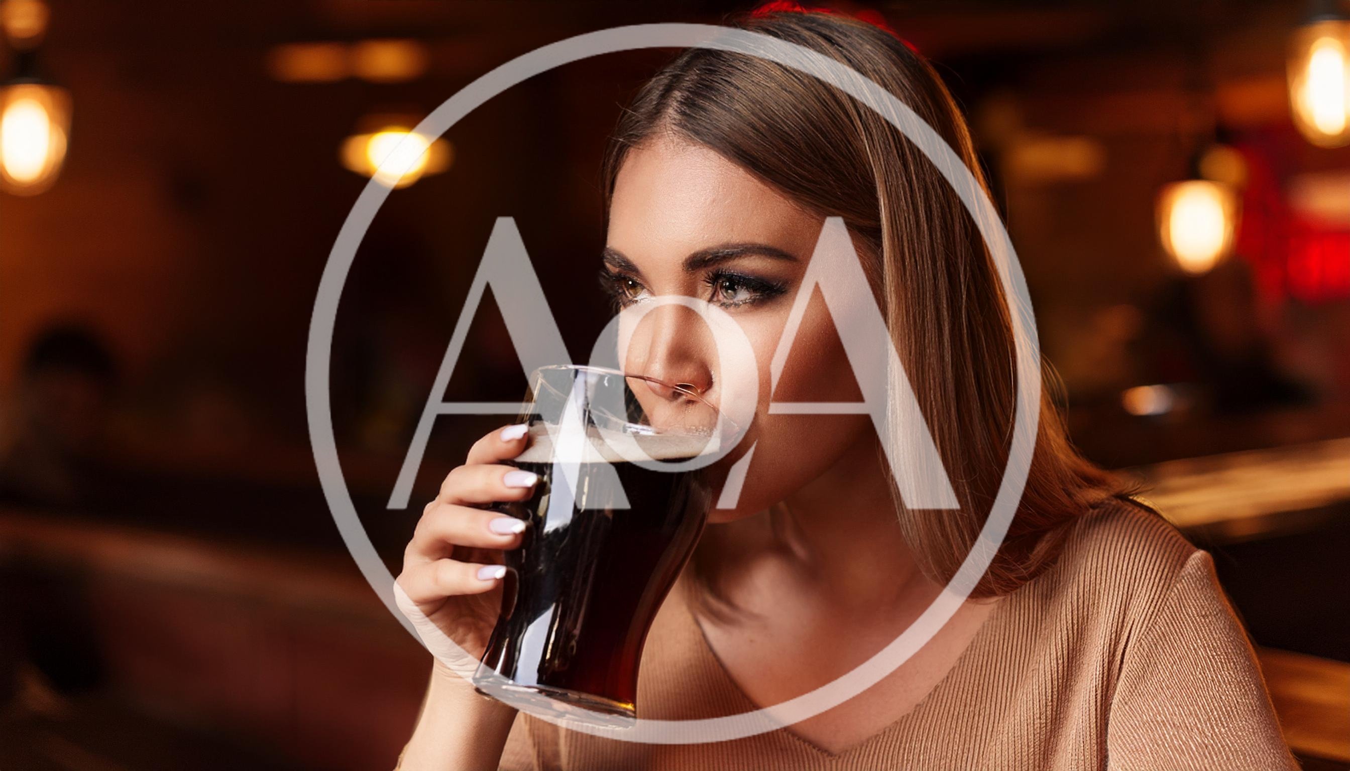 Young Woman Drinking Dark Beer in a Pub