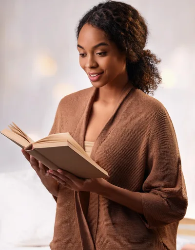 Young Woman Reading A Book In A Cozy Setting
