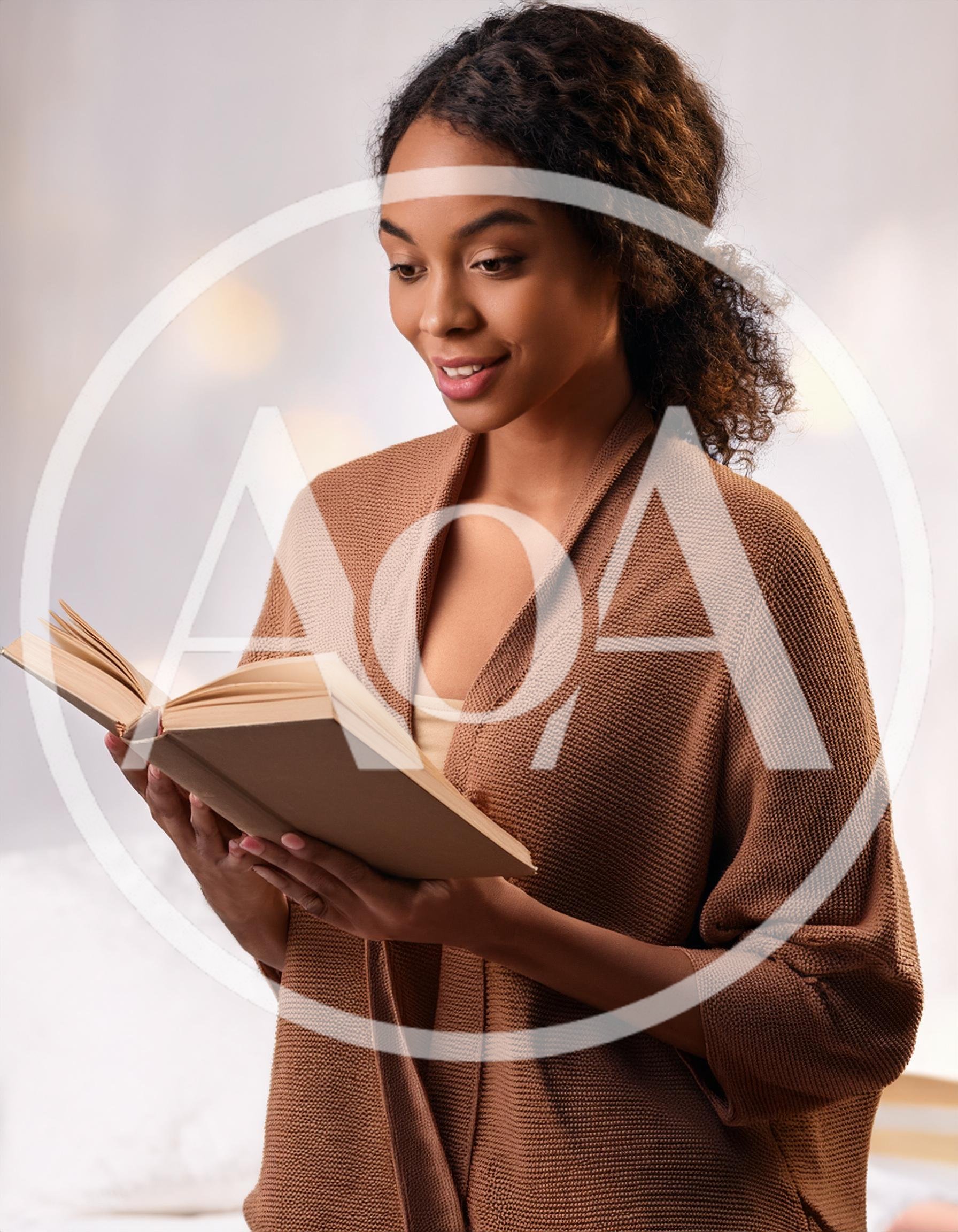 Young Woman Reading A Book In A Cozy Setting