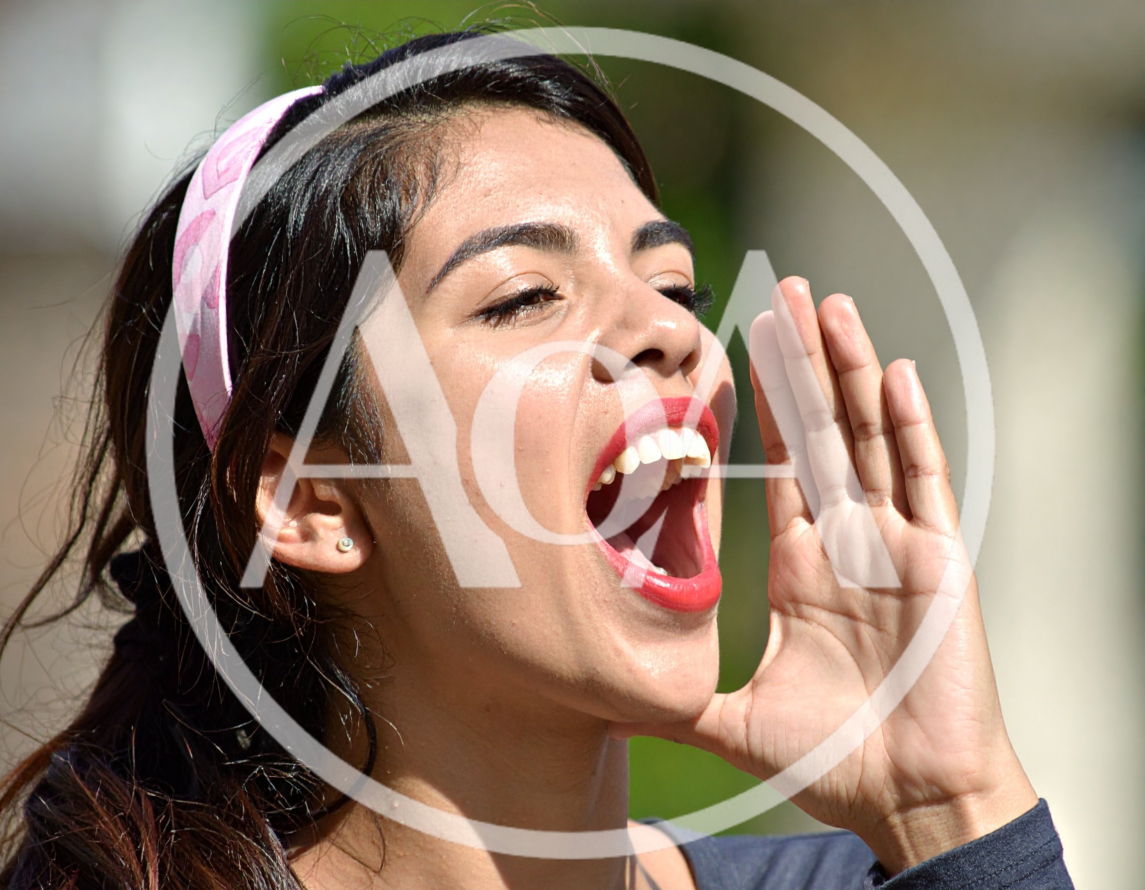 Young Hispanic Woman Shouting With Hand Near Mouth