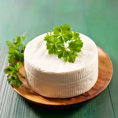 Fresh Round Cheese Wheel With Parsley Garnish