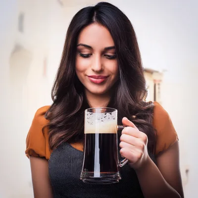 Young Woman Holding A Glass Of Dark Beer