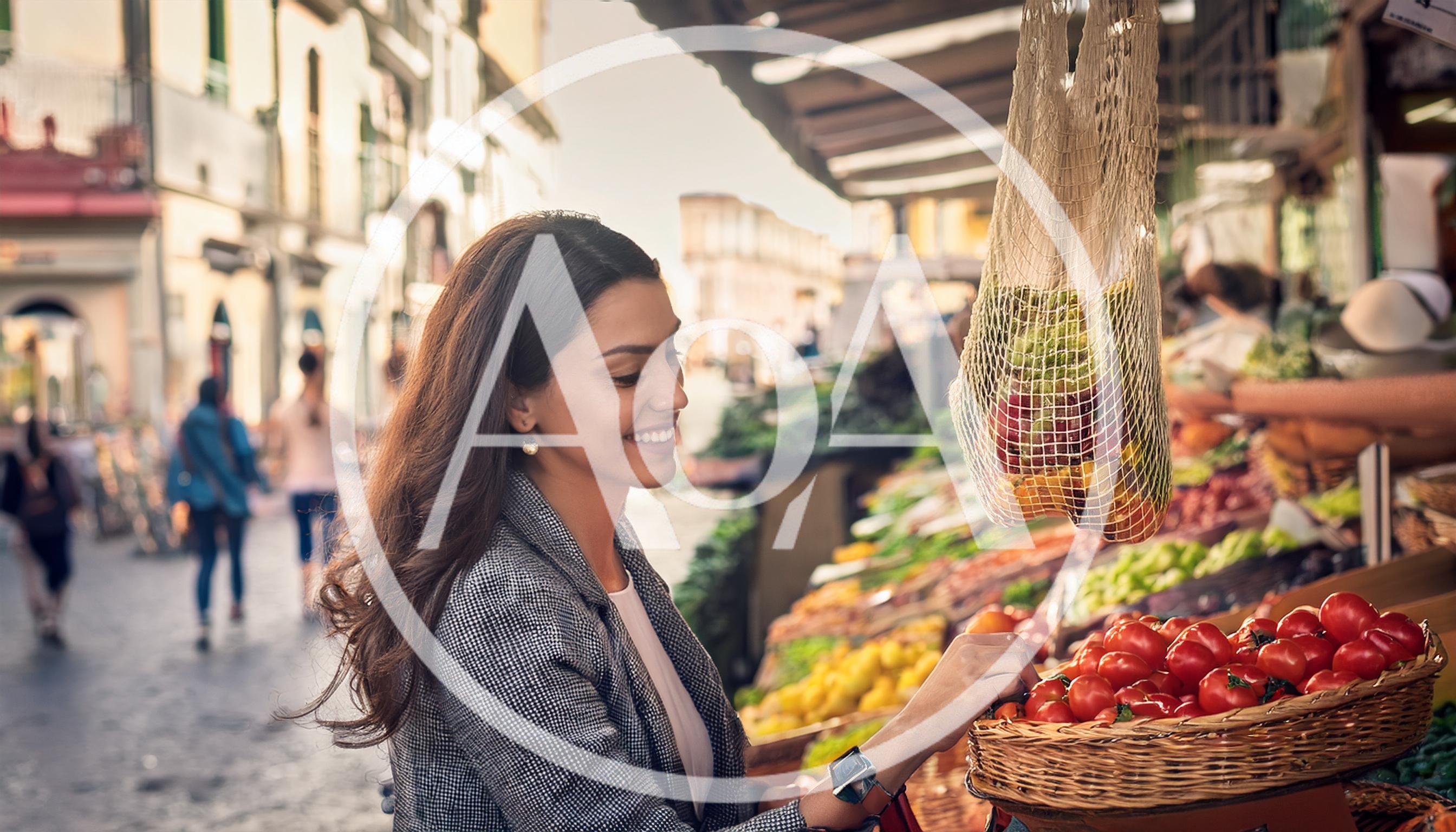 Young Woman Shopping For Fresh Tomatoes At Outdoor Market