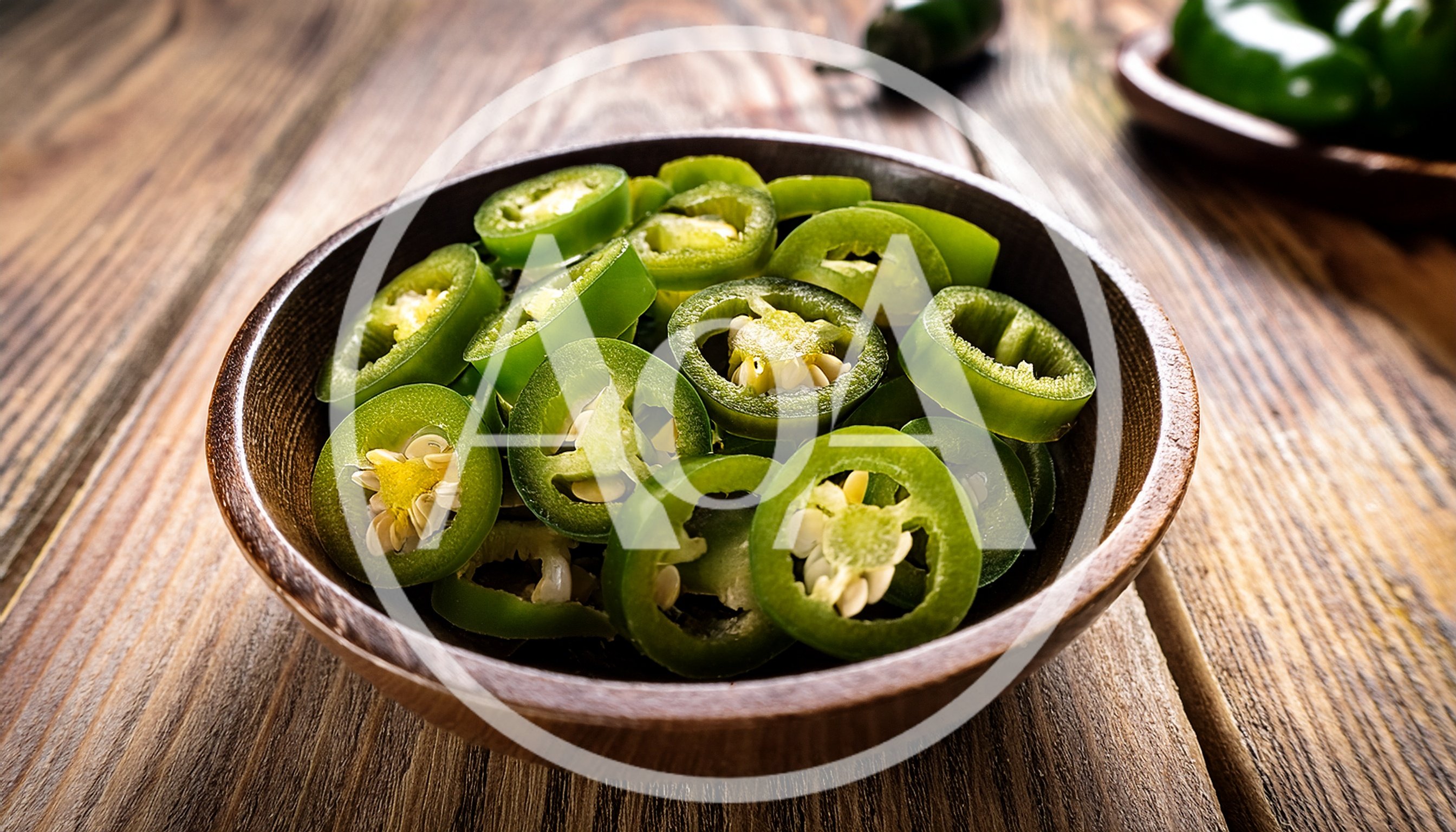 Fresh Sliced Jalapeno Peppers In A Wooden Bowl