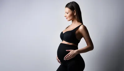 Pregnant Woman Touching Her Belly In Studio