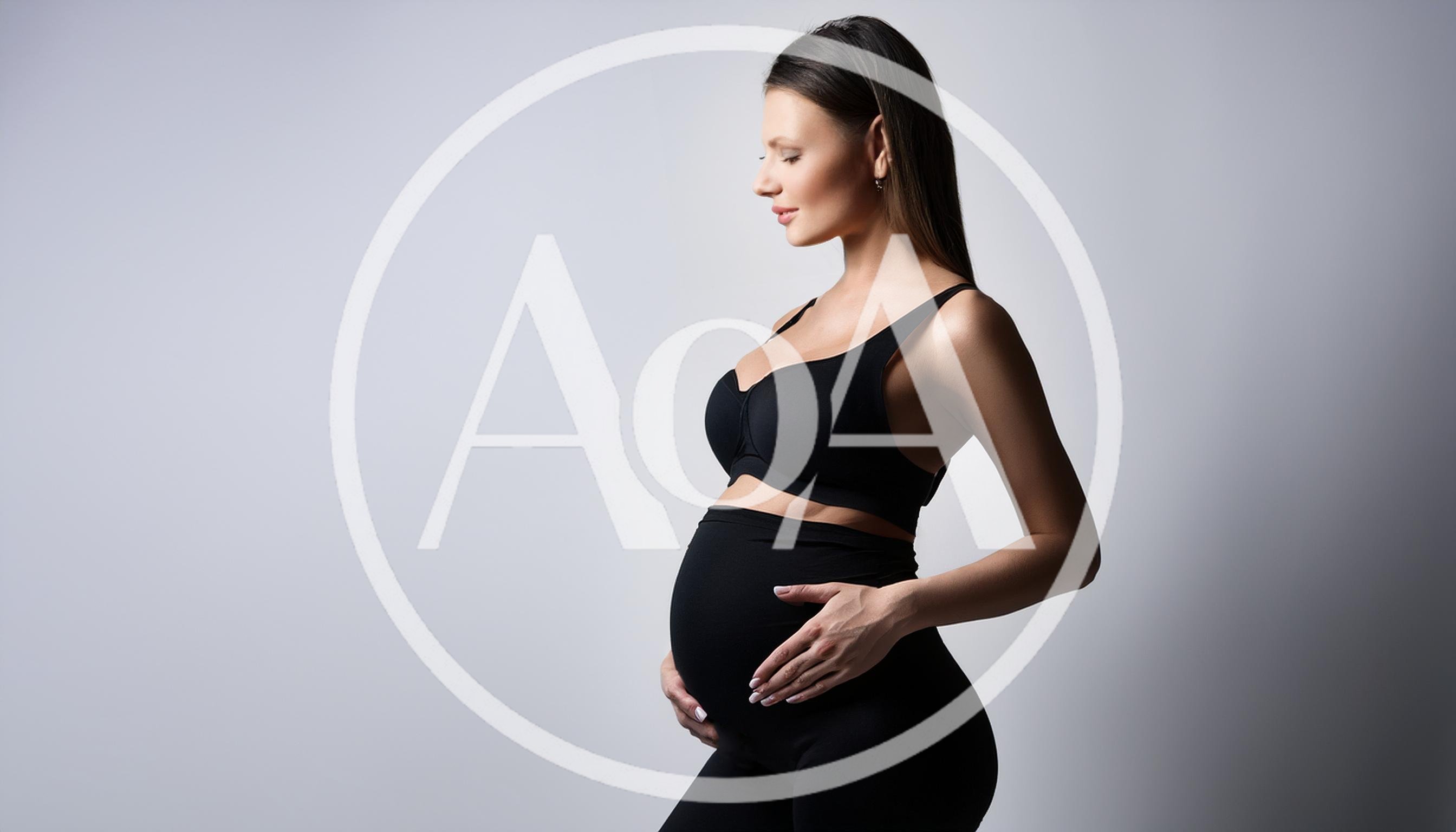 Pregnant Woman Touching Her Belly In Studio