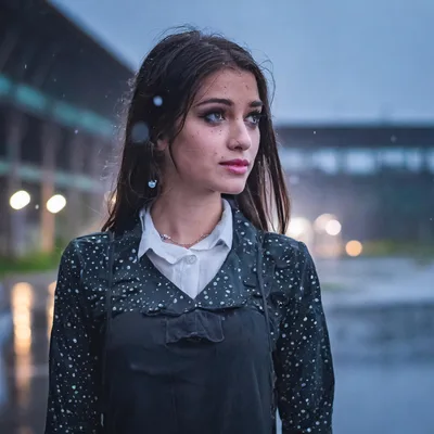 Young Woman Standing Outdoors During A Rainy Evening