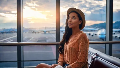 Young Woman Waiting At Airport Terminal During Sunset