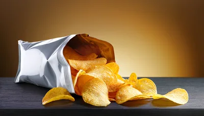 Potato Chips Spilling From A Silver Foil Bag
