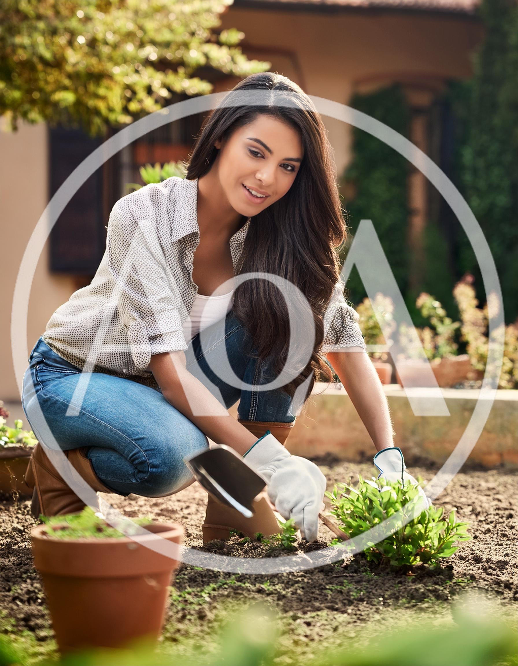 Young Woman Gardening In A Sunny Backyard