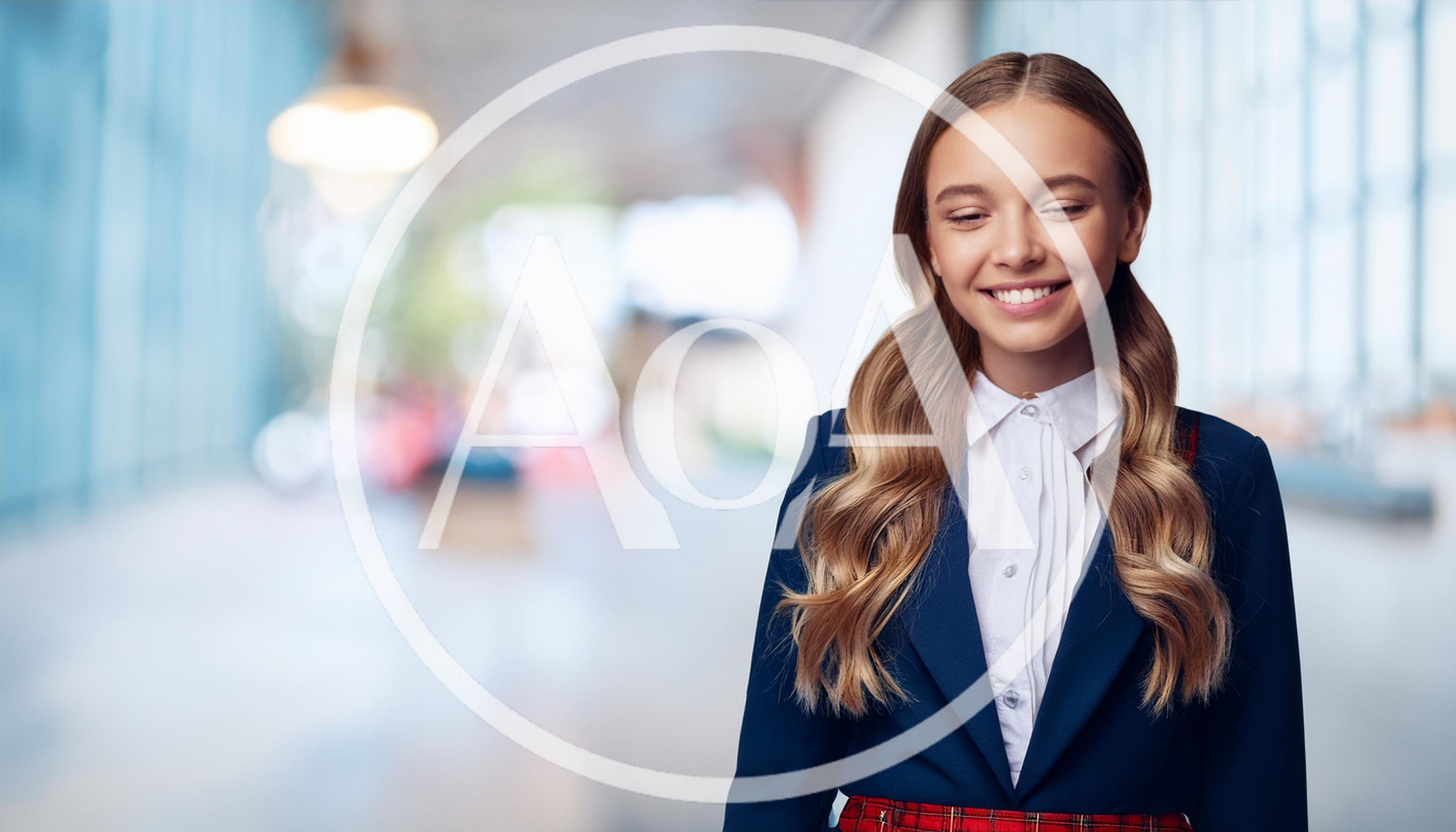 Smiling Schoolgirl In Uniform Standing In Bright Hallway