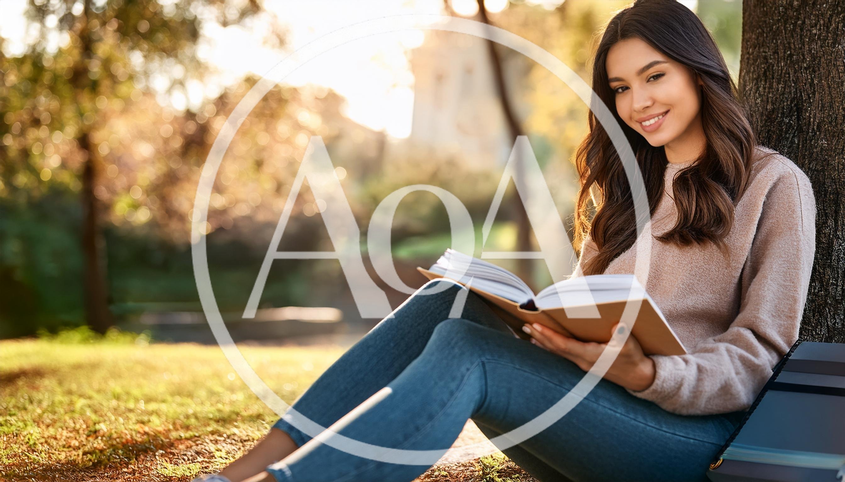 Young Woman Reading A Book Under A Tree