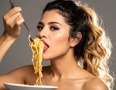 Young Woman Eating Spaghetti With A Fork