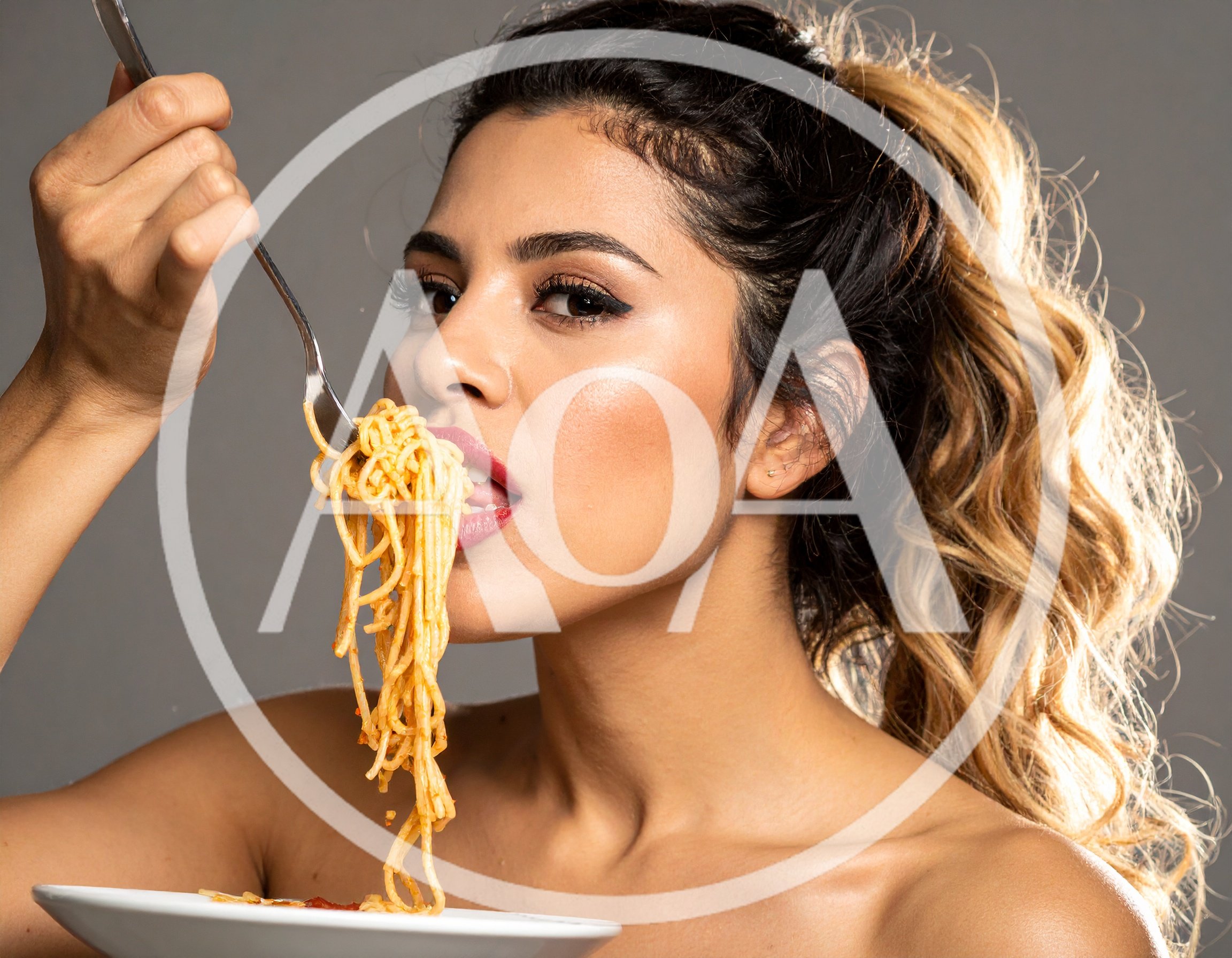 Young Woman Eating Spaghetti With A Fork