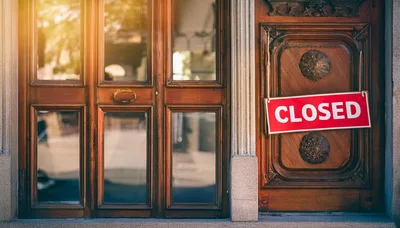 Closed Sign Hanging On A Wooden Storefront Door
