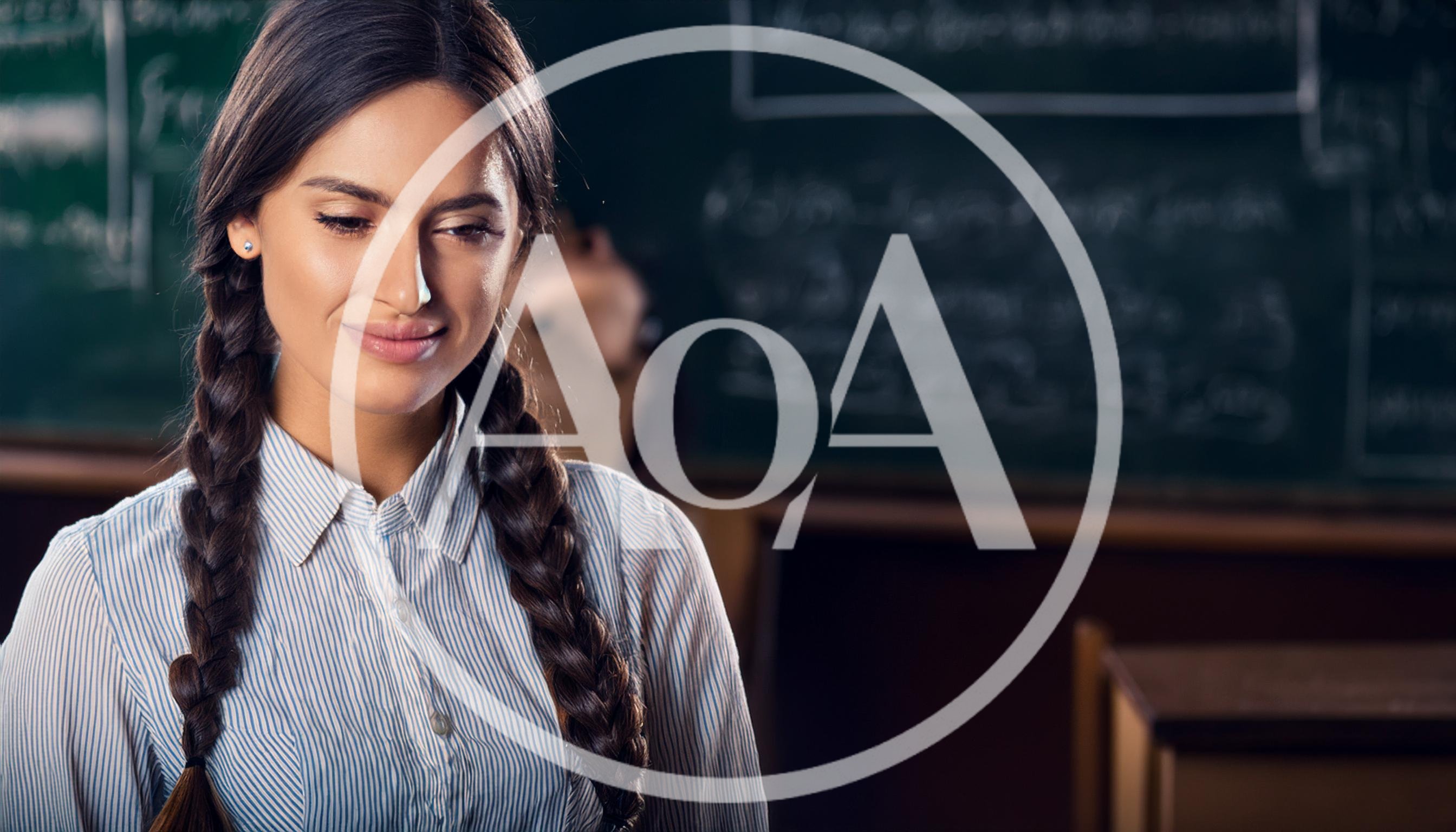 Young Female Teacher Standing In A Classroom