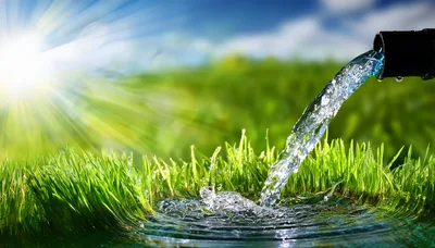 Fresh Water Pouring From Pipe Onto Green Grass
