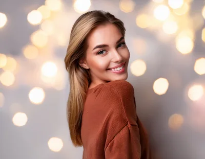 Smiling Young Woman With Blonde Hair In Brown Sweater