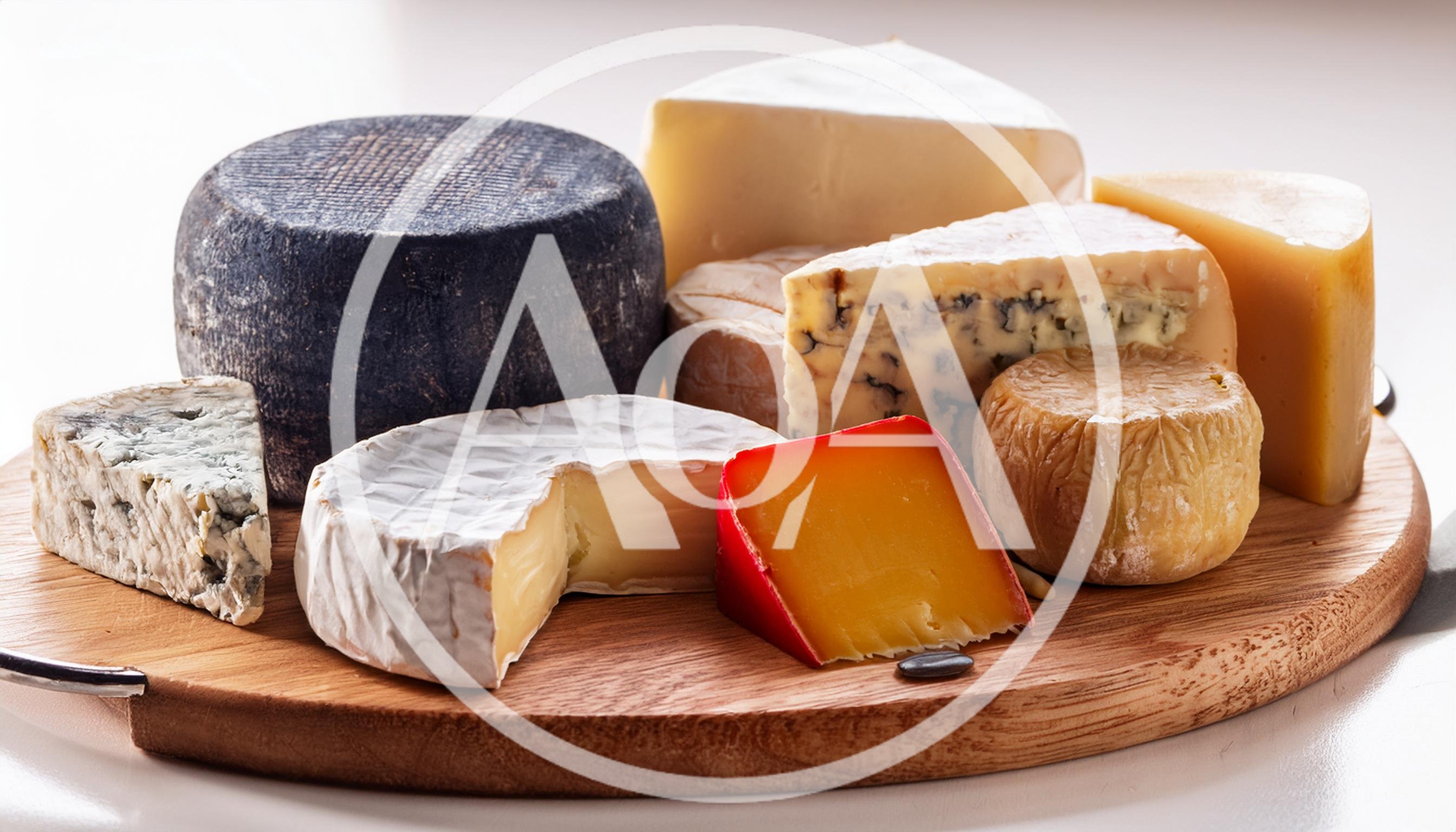 Assorted Gourmet Cheeses Arranged On A Wooden Board