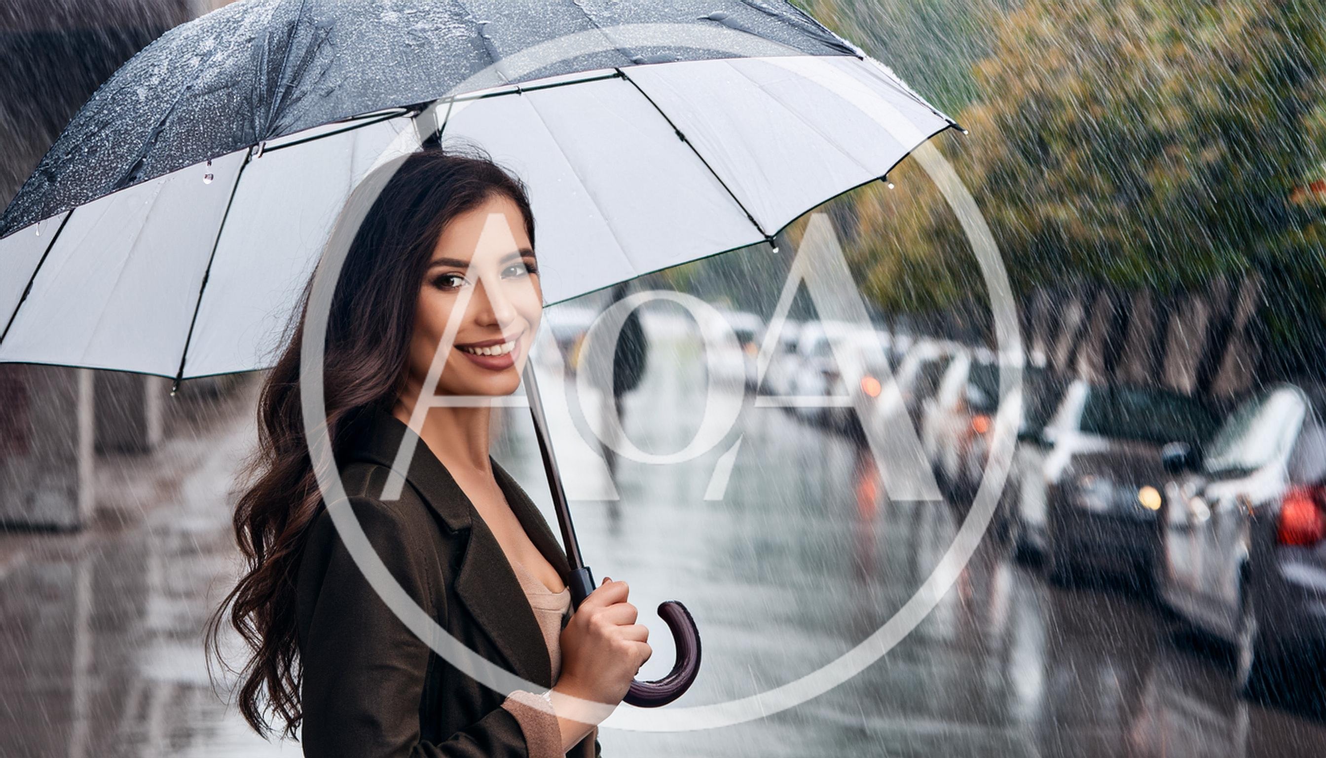 Smiling Woman Holding Umbrella Walking On Rainy City Street