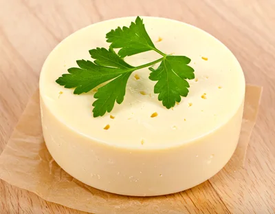 Round Wheel Of Creamy Cheese With Fresh Parsley