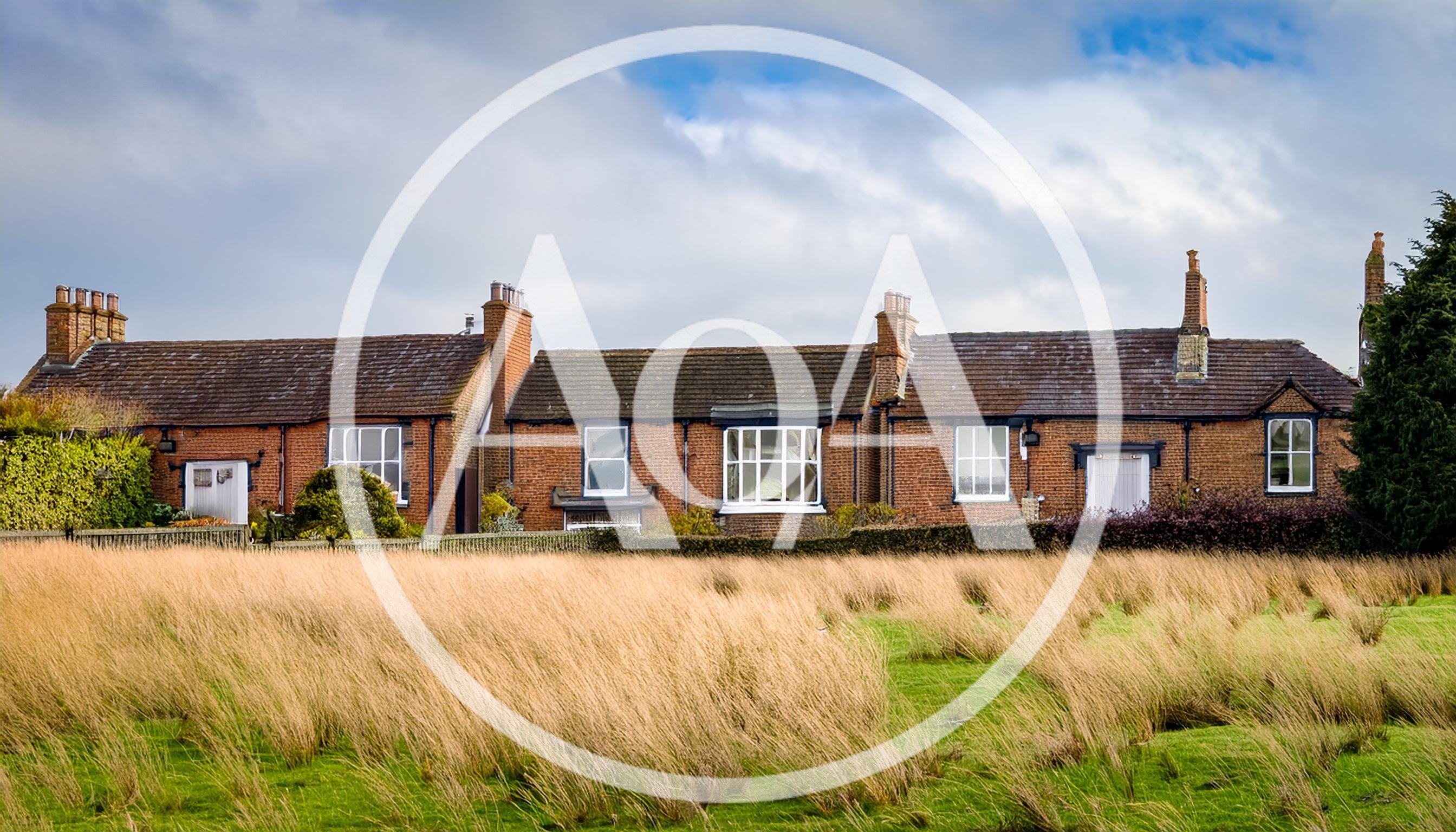 Row Of Traditional English Brick Cottages In Rural Landscape