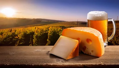 Cheese Wedge And Beer Mug On Wooden Table