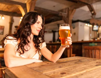 Woman Holding A Glass Of Beer In A Tavern