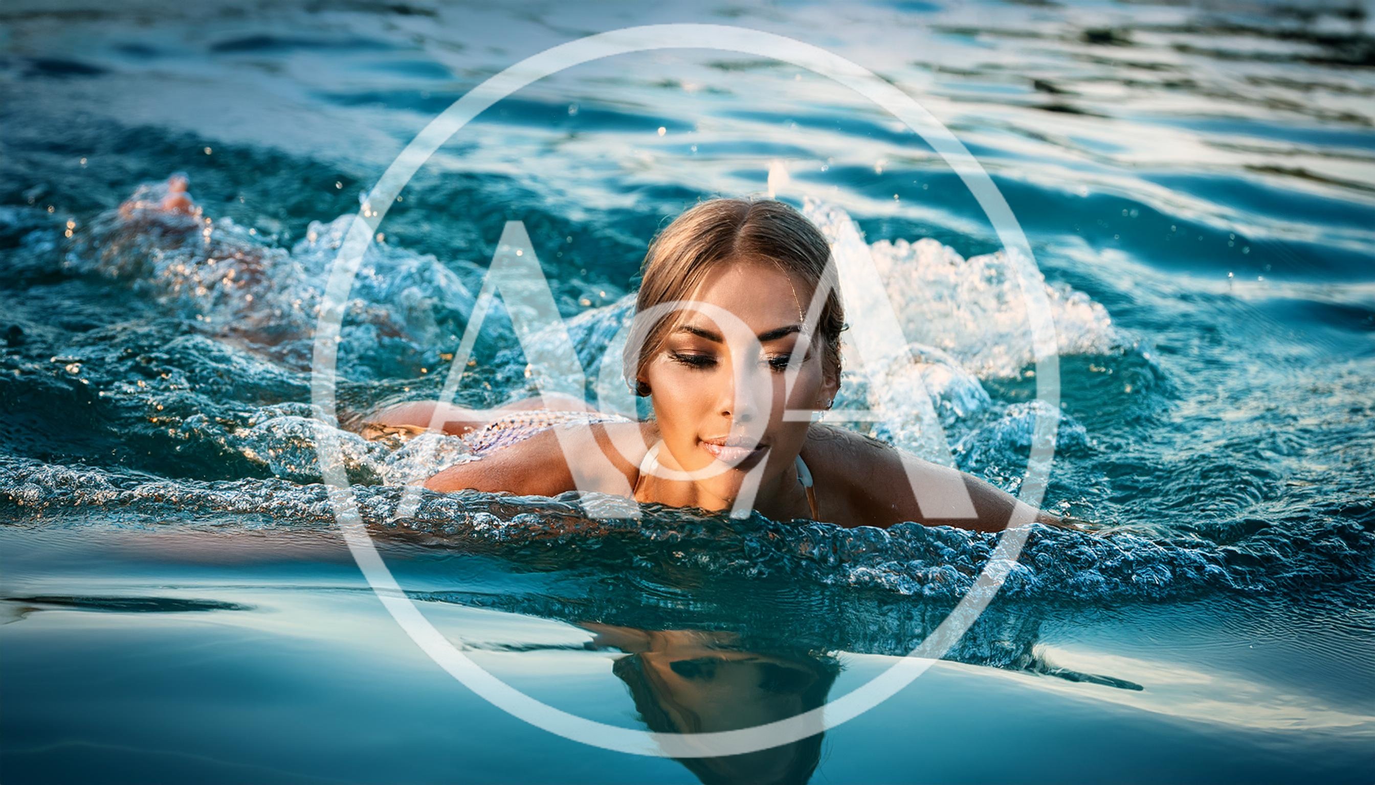Young Woman Swimming In Clear Blue Water