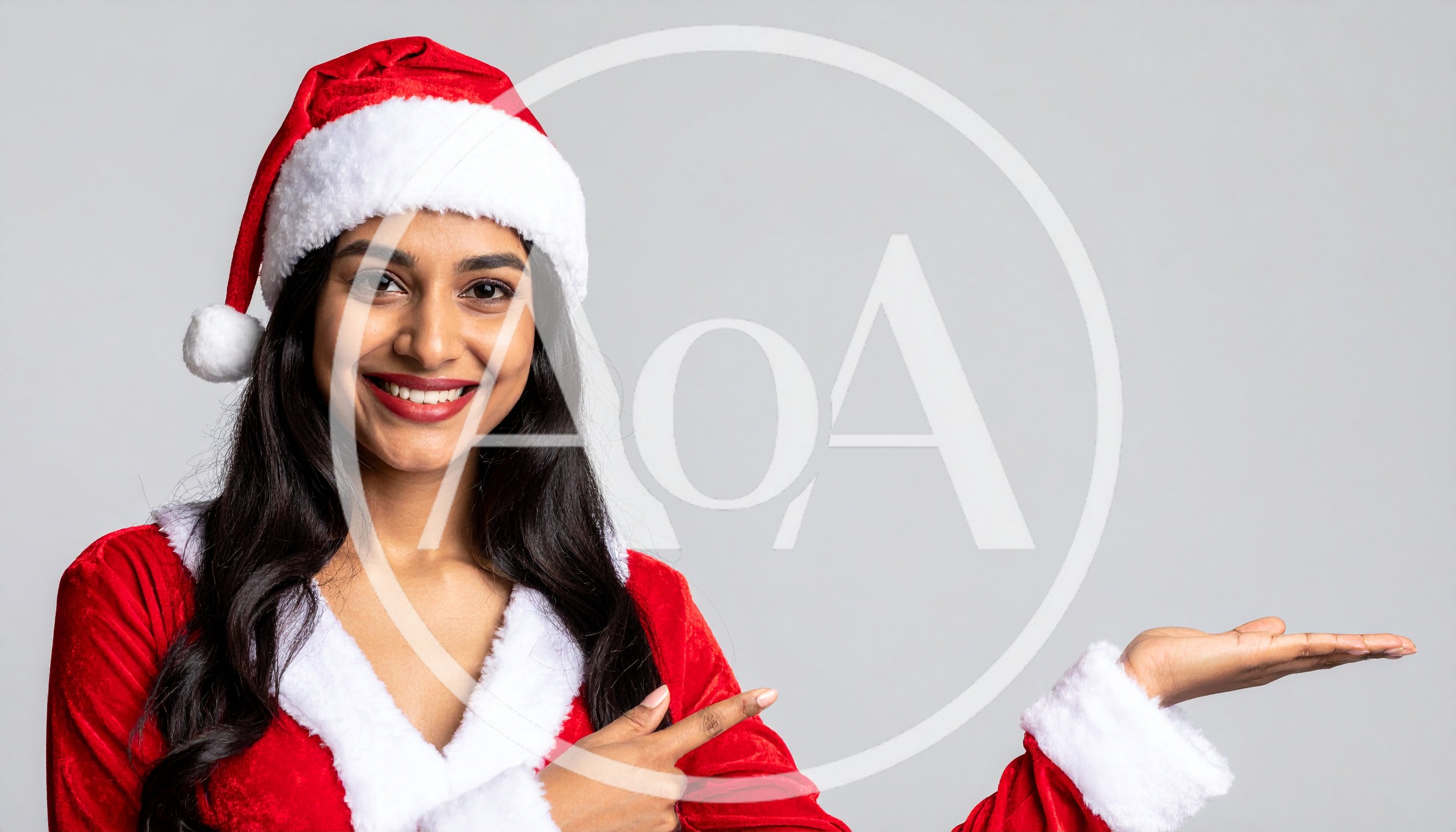 Young Woman In Santa Costume Pointing At Empty Space