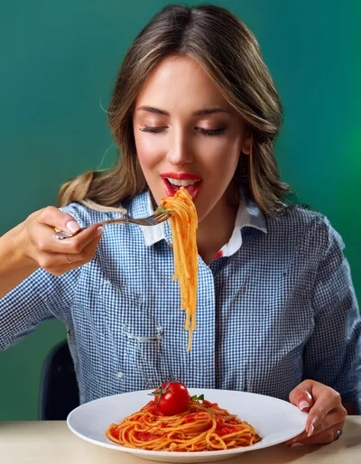 Young Woman Eating Spaghetti With Tomato Sauce