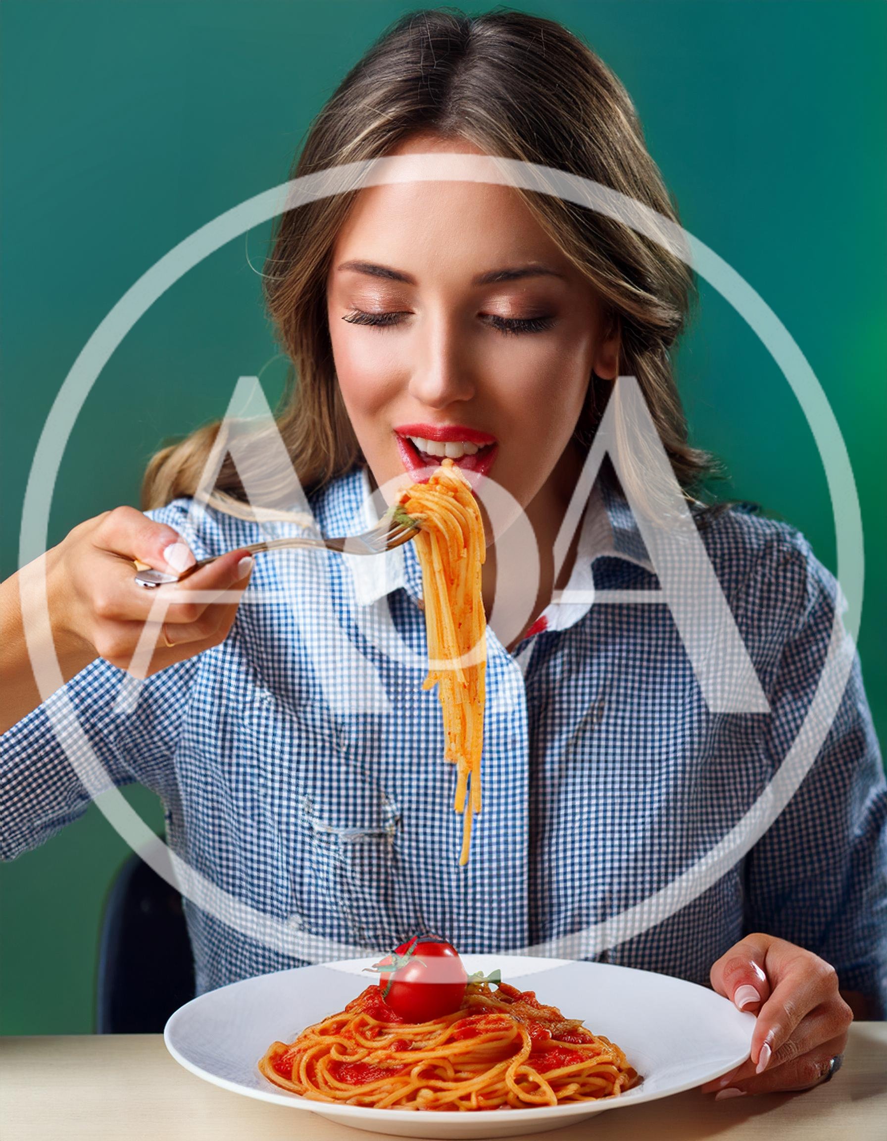 Young Woman Eating Spaghetti With Tomato Sauce