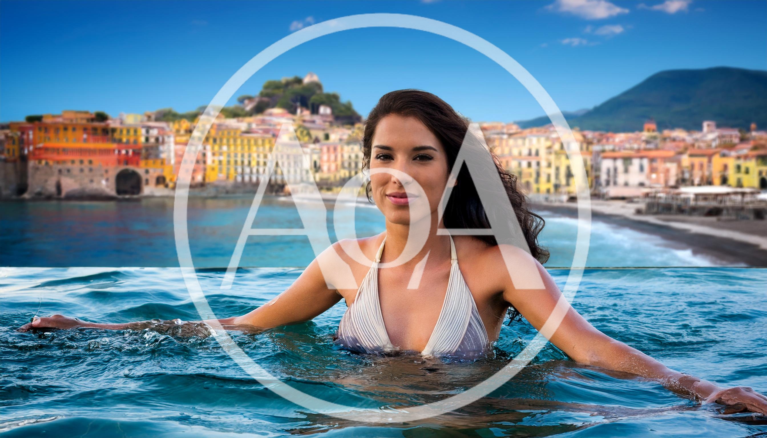Woman Relaxing In An Infinity Pool Overlooking A Coastal Town