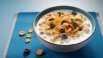 Bowl of Cereal with Milk on Blue Placemat