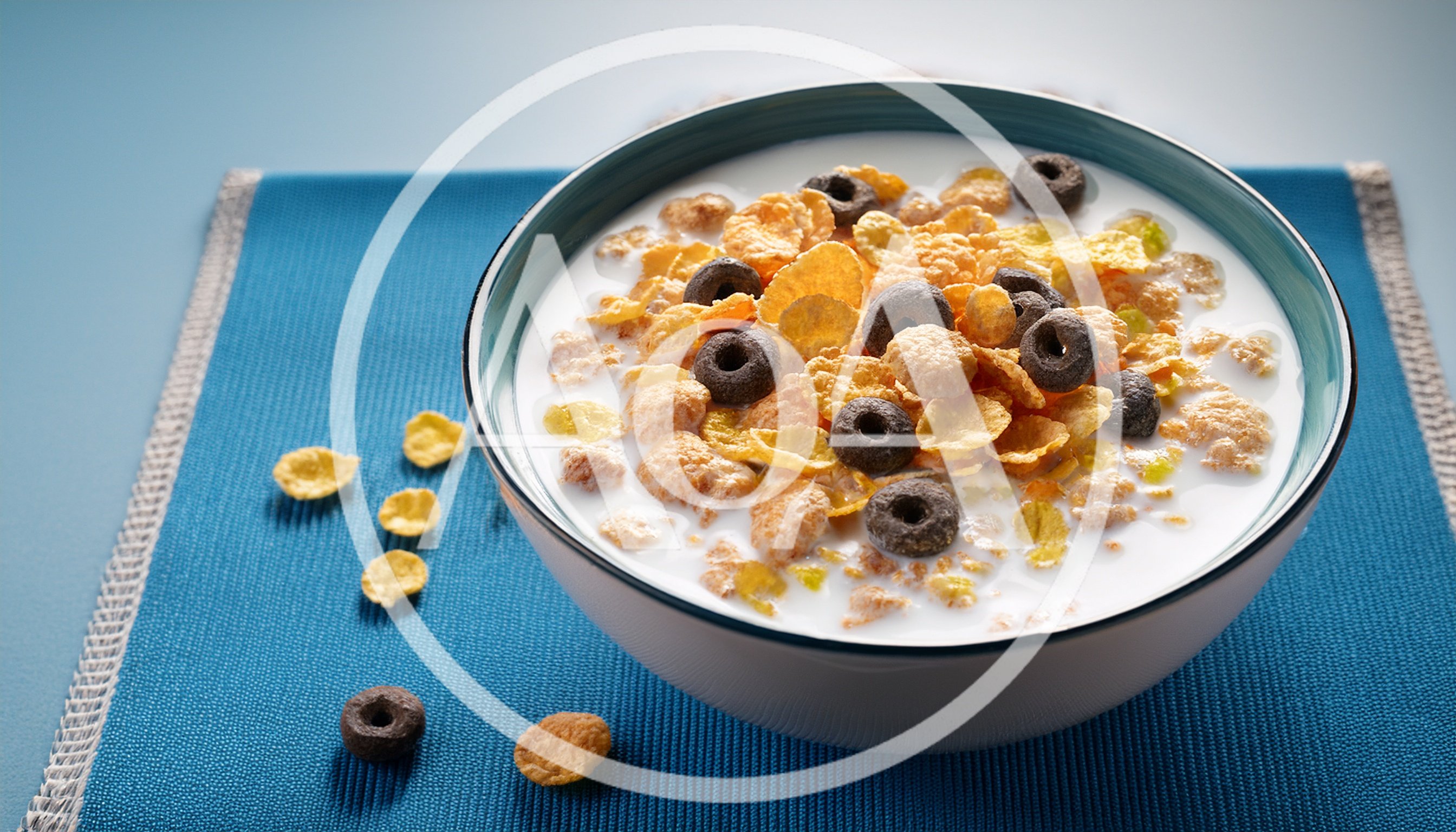 Bowl of Cereal with Milk on Blue Placemat