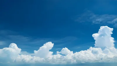 Fluffy White Cumulus Clouds Against A Deep Blue Sky