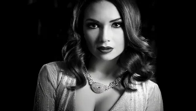 Elegant Woman With Wavy Hair Wearing A Sparkling Necklace