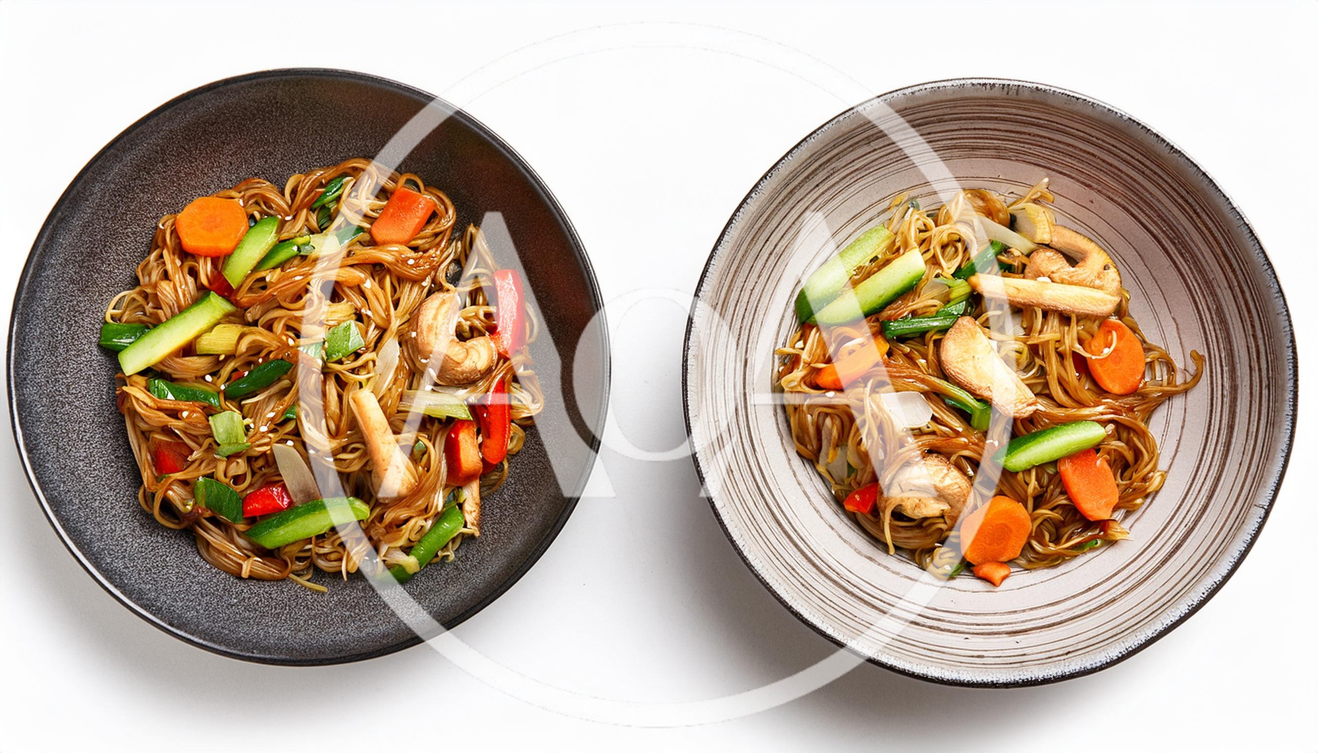 Two Bowls Of Stir Fried Noodles With Vegetables