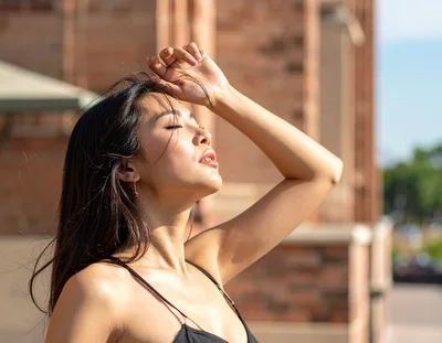 Young Woman Posing Outdoors With Hand On Forehead