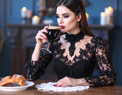Elegant Woman Drinking Dark Beverage in Gothic Attire