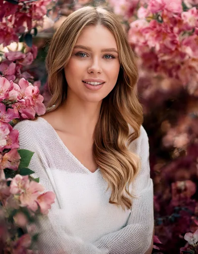 Portrait Of A Beautiful Woman Among Blooming Flowers