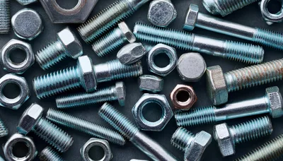 Assorted Metal Bolts and Nuts on Dark Background