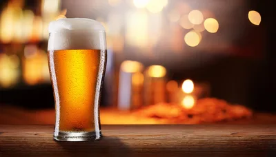 Cold Glass Of Beer On A Wooden Bar Counter