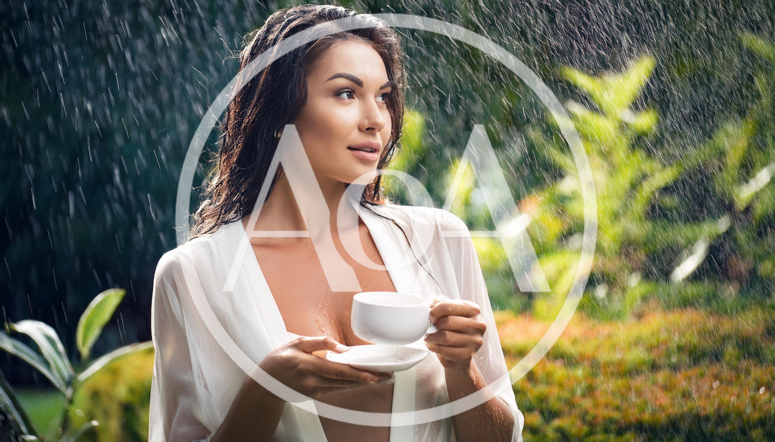 Woman Holding Coffee Cup Under Rain in Tropical Garden