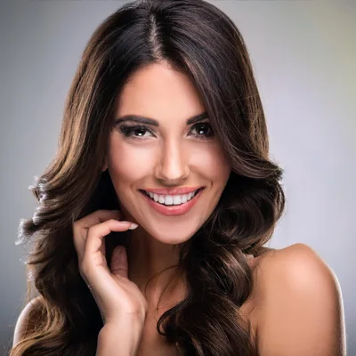 Portrait Of A Smiling Woman With Wavy Brown Hair