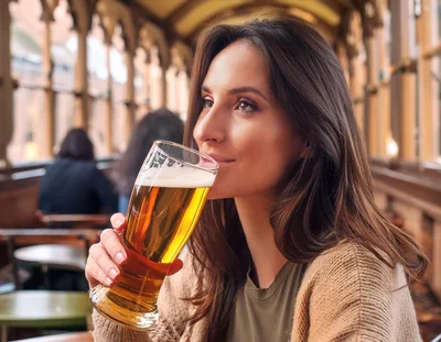 Young Woman Drinking Beer In A Pub